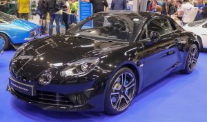 Alpine A110 noire de 2018 vue de trois quarts avant dans un salon automobile ; illustration européenne non contractuelle