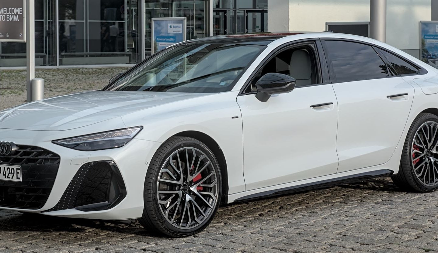 Audi A6 C9 blanche exposée à l'IAA 2025 vue de trois quarts avant ; configuration européenne non contractuelle