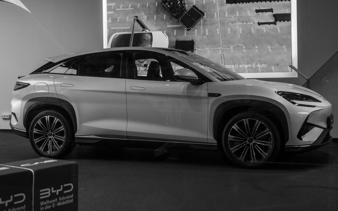 BYD SEALION 7 grise vue de profil dans un showroom ; configuration étrangère non contractuelle