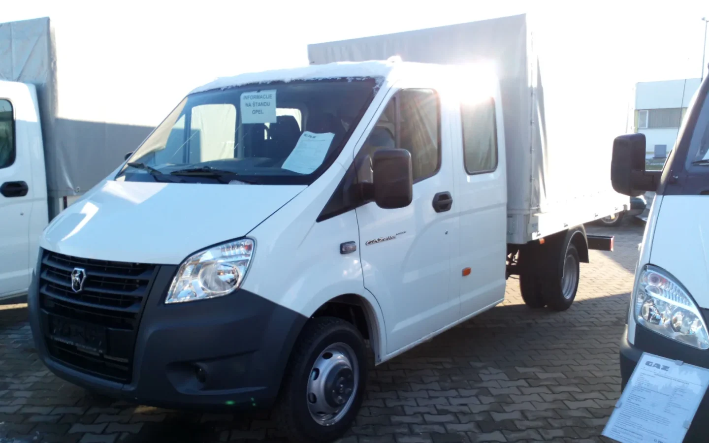 GAZelle Next à cabine longue et plateau bâché vu de trois quarts avant ; configuration étrangère non contractuelle