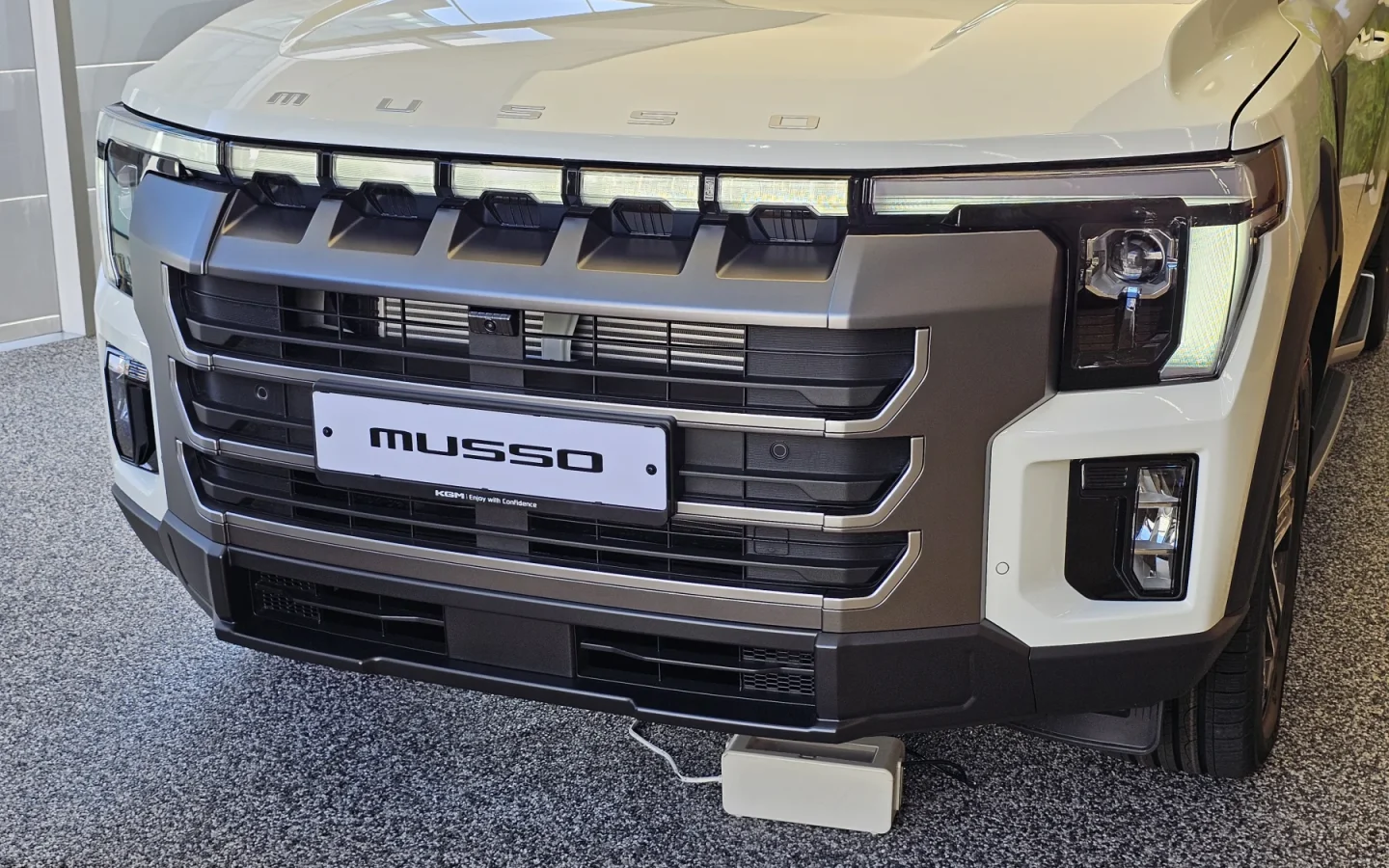 KGM Musso Grand blanc vu de face ; configuration étrangère non contractuelle