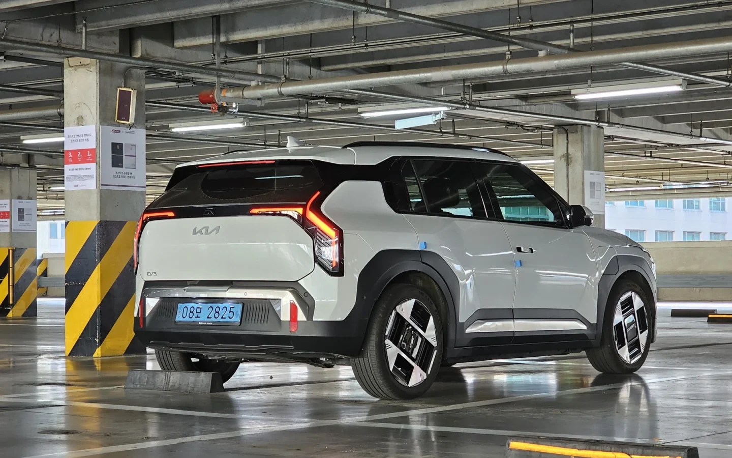 Kia EV3 blanc vu de trois quarts arrière dans un parking couvert