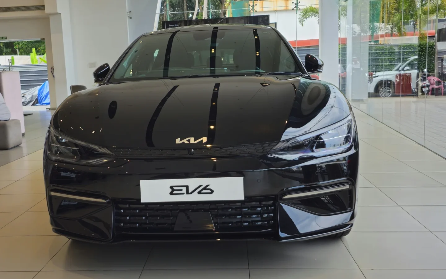 Kia EV6 noir vu de face dans un showroom ; véhicule indien non contractuel