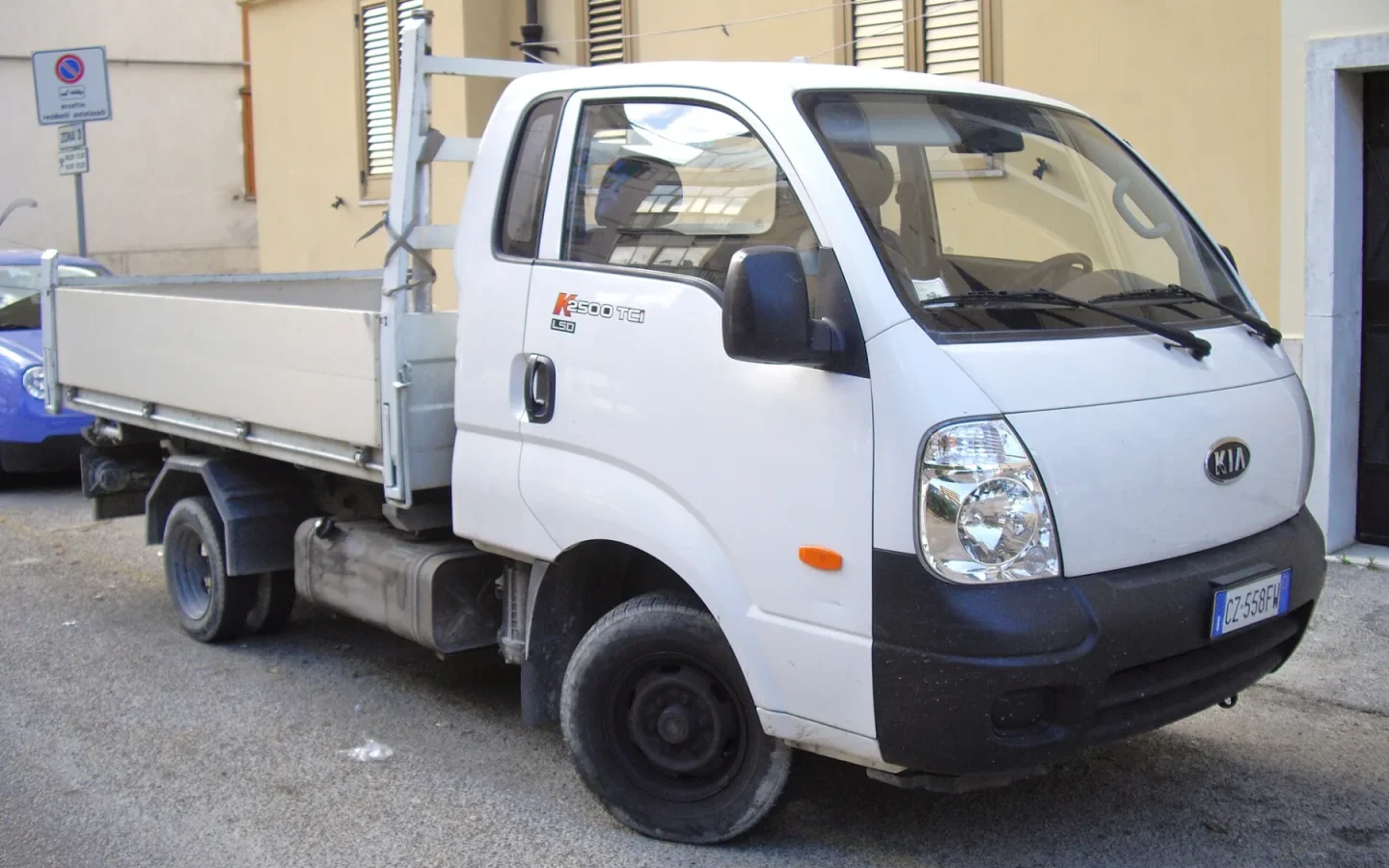 Kia K2500 blanc avec plateau vu de trois quarts avant ; ancienne configuration étrangère non contractuelle
