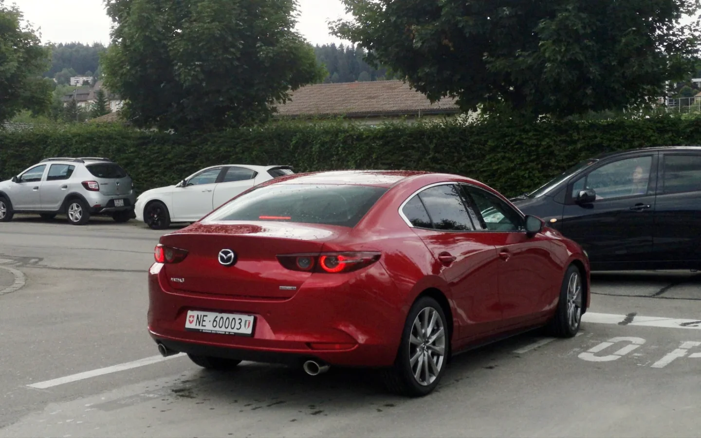 Mazda3 Berline rouge vue de trois quarts arrière ; configuration étrangère non contractuelle