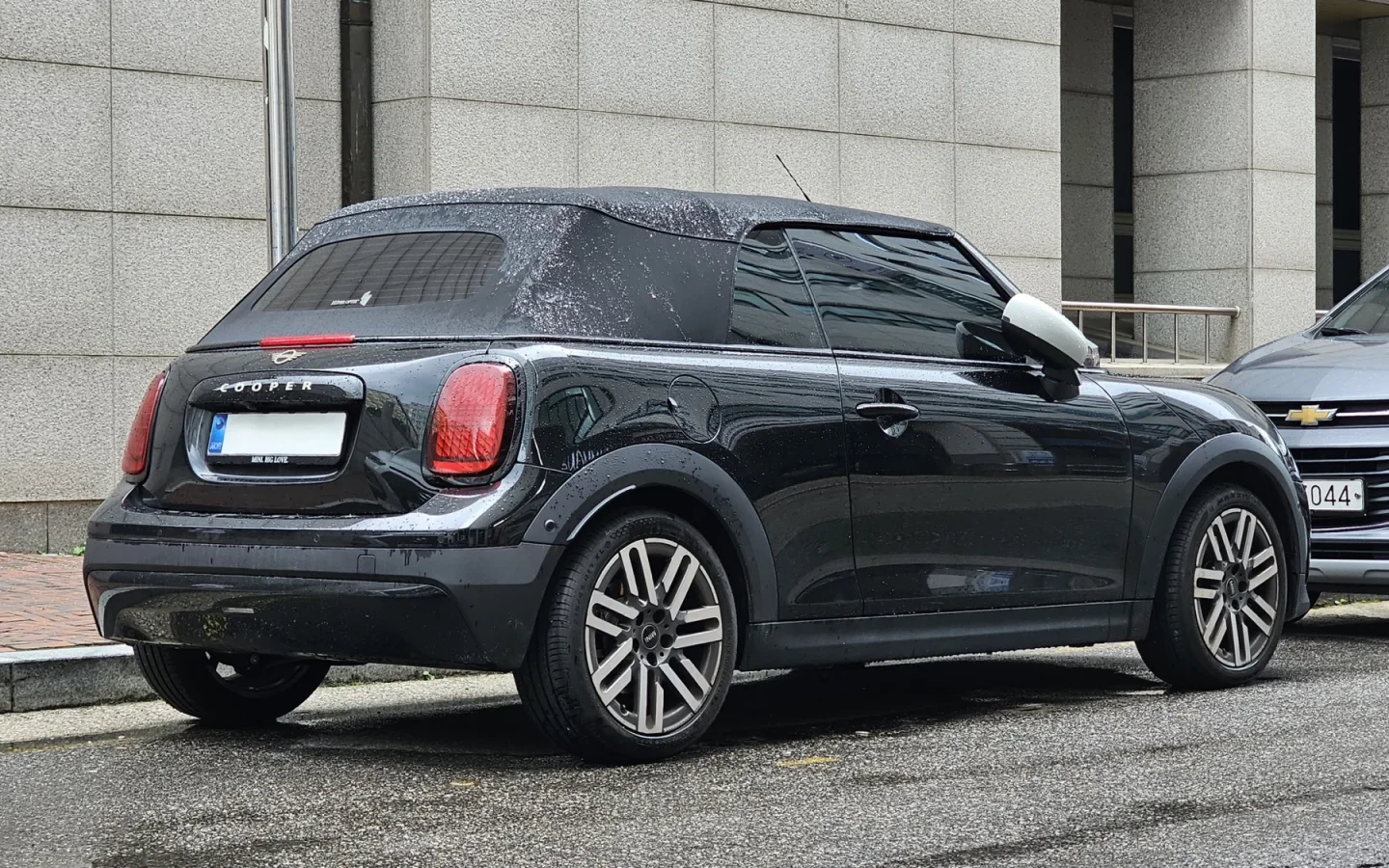 MINI Cooper Cabrio F67 noire vue de trois quarts arrière, capote fermée ; configuration étrangère non contractuelle