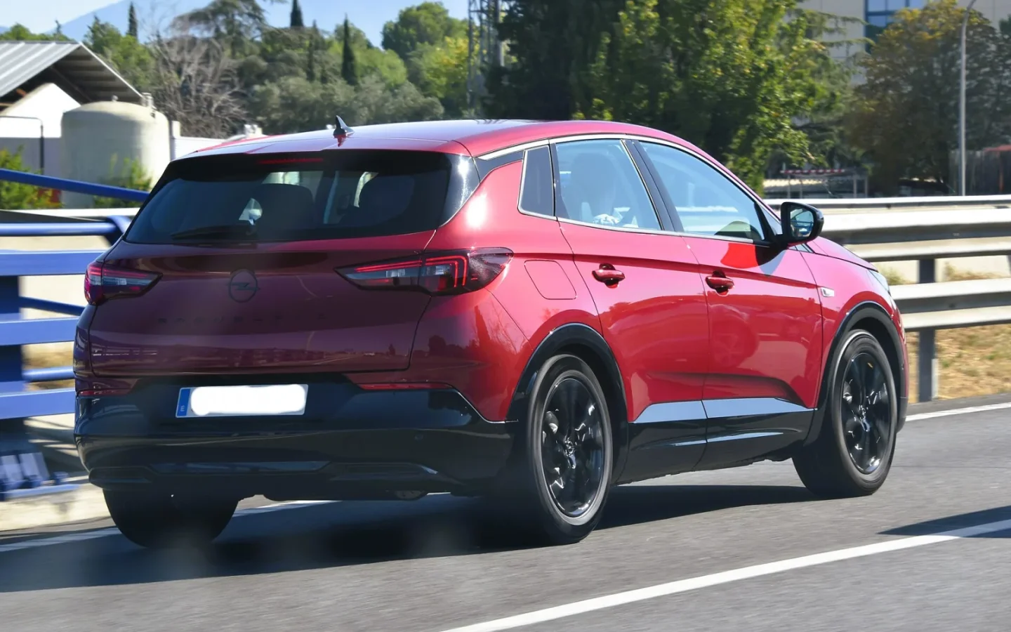 Opel Grandland rouge de 2024 vu de trois quarts arrière ; configuration étrangère non contractuelle