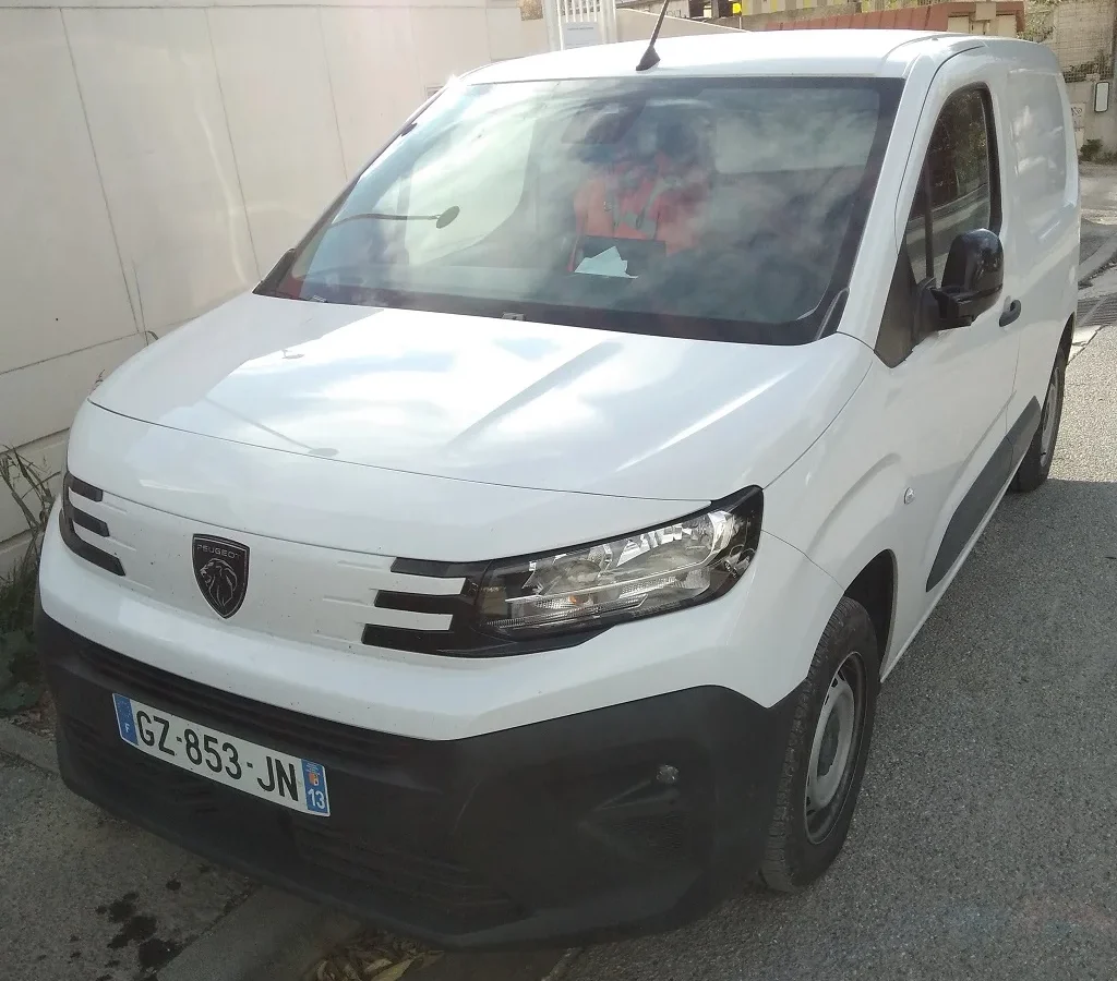 Peugeot Partner III restylé blanc vu de trois quarts avant ; véhicule français non contractuel