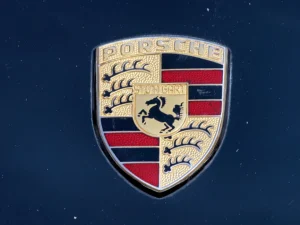 Blason Porsche photographié sur une carrosserie bleue