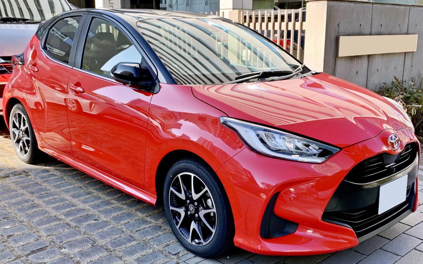 Toyota Yaris XP210 rouge à toit noir, vue de trois quarts avant; illustration non contractuelle de la génération