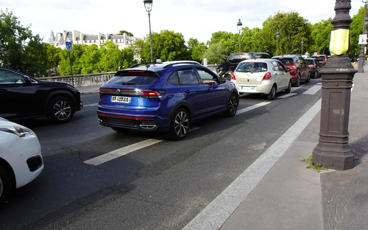Volkswagen Taigo bleu vu de trois quarts arrière dans la circulation ; configuration européenne non contractuelle
